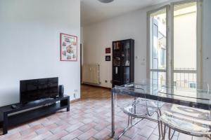 ein Wohnzimmer mit einem Glastisch und Stühlen in der Unterkunft Castiglione Family Apartment by Wonderful Italy in Bologna
