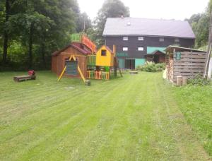 un patio con parque infantil y una casa en Kosanda, en Branná