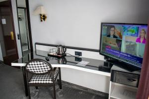 pokój ze stołem, telewizorem i krzesłem w obiekcie La Conacul Vesel Săpânța w mieście Săpânța