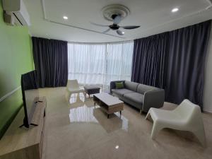 sala de estar con sofá y TV en Suria Homestay Bangi, en Kampong Sungai Merab