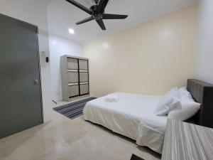 1 dormitorio con 1 cama y ventilador de techo en Suria Homestay Bangi, en Kampong Sungai Merab