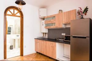 a kitchen with wooden cabinets and a stainless steel refrigerator at Classy Apartment Unirii Square in Bucharest