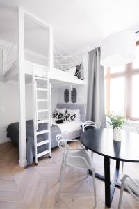 a white bedroom with a bunk bed and a table at Homewell Apartments Wilson Park II in Poznań