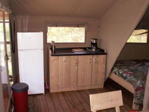 a small kitchen in a tent with a refrigerator at Camping les Silhols in Lagorce