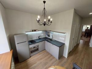 a kitchen with a refrigerator and a chandelier at Квартира в самом центре in Almaty