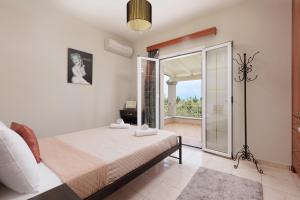 a bedroom with a bed and a sliding glass door at Villa Mythos with Infinity Pool in Dassia +12 photos