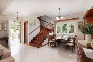 a kitchen and dining room with a staircase and a table at Villa Mythos with Infinity Pool in Dassia