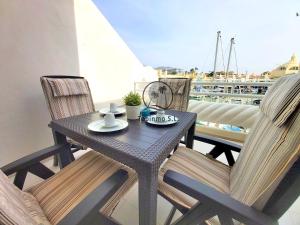 czarny stół i krzesła na balkonie z łodzią w obiekcie Nordic 1 bedroom apartment on Island complex in marina harbour w mieście Benalmádena