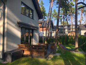 a house with a porch with a hammock in the yard at Villa Ohana in Pobierowo 300 m from the beach in Pobierowo