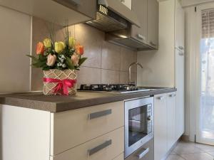 eine Küche mit einer Theke mit einer Vase aus Blumen in der Unterkunft Milady in Rosolina Mare