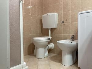 ein Badezimmer mit Toilette und Waschbecken in der Unterkunft Milady in Rosolina Mare + 28 Fotos