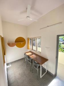 een eetkamer met een houten tafel en stoelen bij Habitat15@airlines in Bangalore