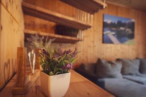 een woonkamer met een vaas met bloemen op een tafel bij Hüttendorf Hohentauern - Dein Feriendomizil in den Bergen in Hohentauern