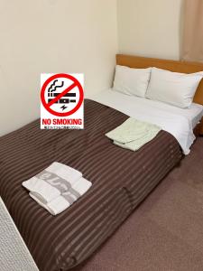 um sinal para não fumadores numa cama num quarto em Matsue Urban Hotel Lake Inn em Matsue