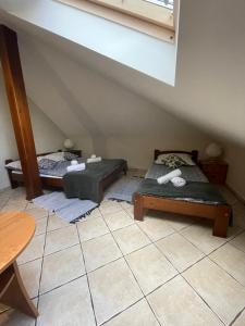 a room with two beds and a table in a room at Restauracja Rozmarzyn in Ostrzeszów
