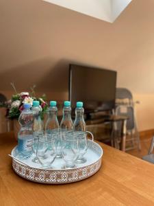 ein Tablett mit Weinflaschen und Weingläsern auf dem Tisch in der Unterkunft Restauracja Rozmarzyn in Schildberg
