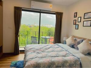 a bedroom with a bed and a view of a balcony at La Habana Huahin by Ying in Hua Hin