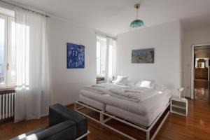a white bedroom with a bed and a couch at B&B villa sempreverde in Locarno