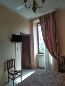 ein Schlafzimmer mit einem Bett, einem Stuhl und einem Fenster in der Unterkunft Agriturismo Il Casale del Cavaliere in SantʼAgata deʼ Goti