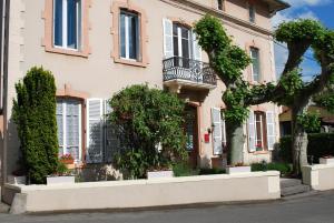 una casa rosa con un árbol delante en L'Hôtel L'Astrée en Feurs