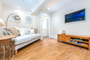 a living room with a white couch and a tv at The Bear in Usk