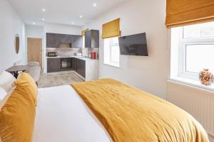 a bedroom with a bed with a yellow blanket on it at Host & Stay - Studio Pods in Saltburn-by-the-Sea