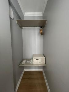 a small walk in closet with a microwave on a shelf at AZRA SULTAN HOTEL&SPA in Istanbul