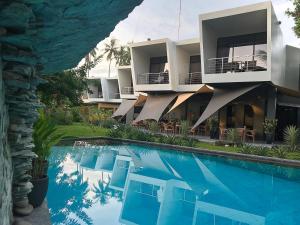 a hotel with a swimming pool in front of a building at Mahi Mahi Dive Resort in Zamboanguita