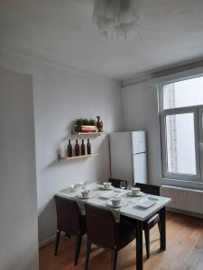 d'une salle à manger avec une table, des chaises et un réfrigérateur. dans l'établissement Sint Andries Duplex, à Anvers