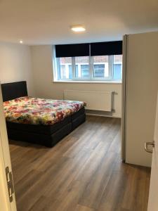 - une chambre avec un lit et du parquet dans l'établissement Sint Andries Duplex, à Anvers