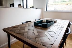 a dining room table with a black box on it at 2 Bed Ground Floor Apartment - 3 Plas in Pistyll