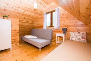 a room with a couch in a log cabin at domki letniskowe Ustka Sosnowo in Ustka