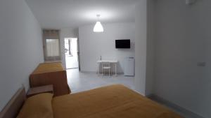 a white room with two beds and a table at Rosa's Rooms in Matera