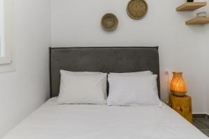 een bed met witte lakens en kussens in een slaapkamer bij Bleu clair luxury living in Argostoli