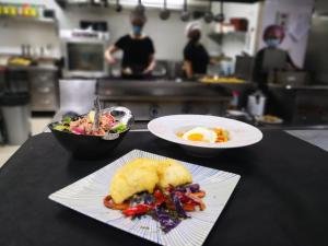 a table with two plates of food and a bowl of salad at Hotel Aro'S in Casas Ibáñez