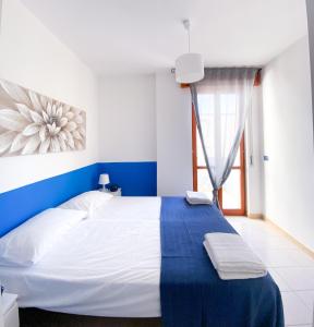 ein blau-weißes Schlafzimmer mit einem großen Bett in der Unterkunft RodiMare in Rodi Garganico + 25 Fotos
