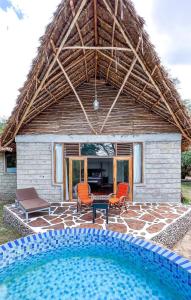 a house with a swimming pool in front of it at Mara Sweet Acacia Lodge in Talek