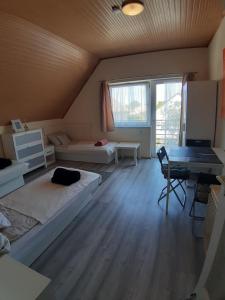 Großes Zimmer mit 2 Betten und einem Schreibtisch. in der Unterkunft MiniBali Apartmanok in Siófok