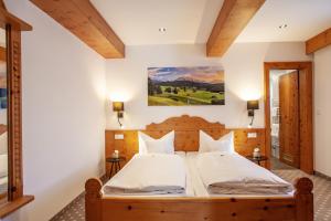 a bedroom with a large bed with a painting on the wall at Gästehaus Sonnenheim in Mittenwald