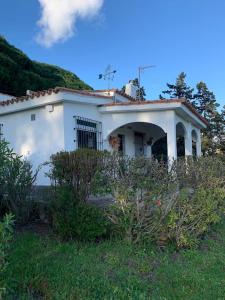 a small white house with a grassy yard at Finca Dos Vientos Tarifa in Tarifa