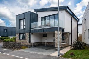 a black and white house with glass windows at Beach Haven in Perranporth