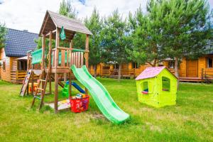 a playground with a slide and a play house at domki letniskowe Ustka Sosnowo in Ustka