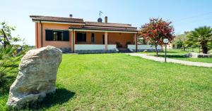una gran roca frente a una casa en Albarosa, en Fertilia 22 fotos más