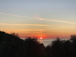 a sunset over the ocean with the sun in the sky at HMO Glamping & Suites in Vignanotica in Mattinata