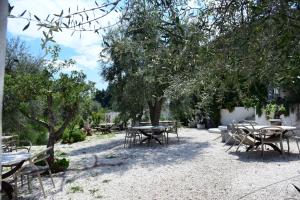 a group of tables and chairs under a tree at HMO Glamping & Suites in Vignanotica in Mattinata