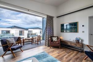 a living room with a large sliding glass door at Beach Haven in Perranporth