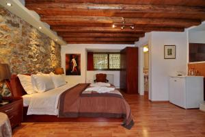1 dormitorio con cama y pared de piedra en Guesthouse Stemnitsa, en Stemnitsa