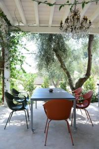 a blue table and chairs in a patio with a chandelier at HMO Glamping & Suites in Vignanotica in Mattinata