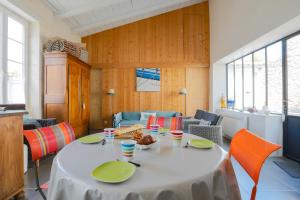 une salle à manger avec une table blanche et des chaises orange dans l'établissement A deux pas du marche, Maison 6 personnes - Grand Port, à Sainte-Marie de Ré