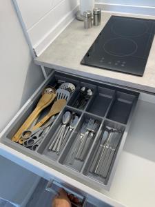 a drawer in a kitchen filled with utensils at Wohlfühlwohnung in Halstenbek in Halstenbek